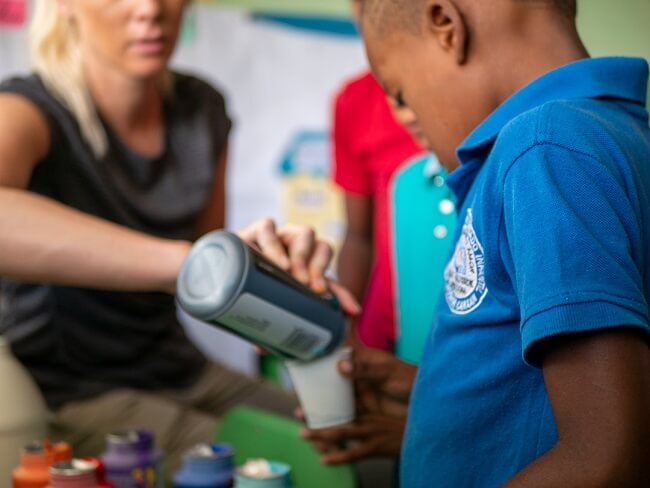 A nonprofit worker pours drinks at a fundraiser