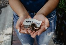 A person holds change and a strip of paper reading "Make a change"